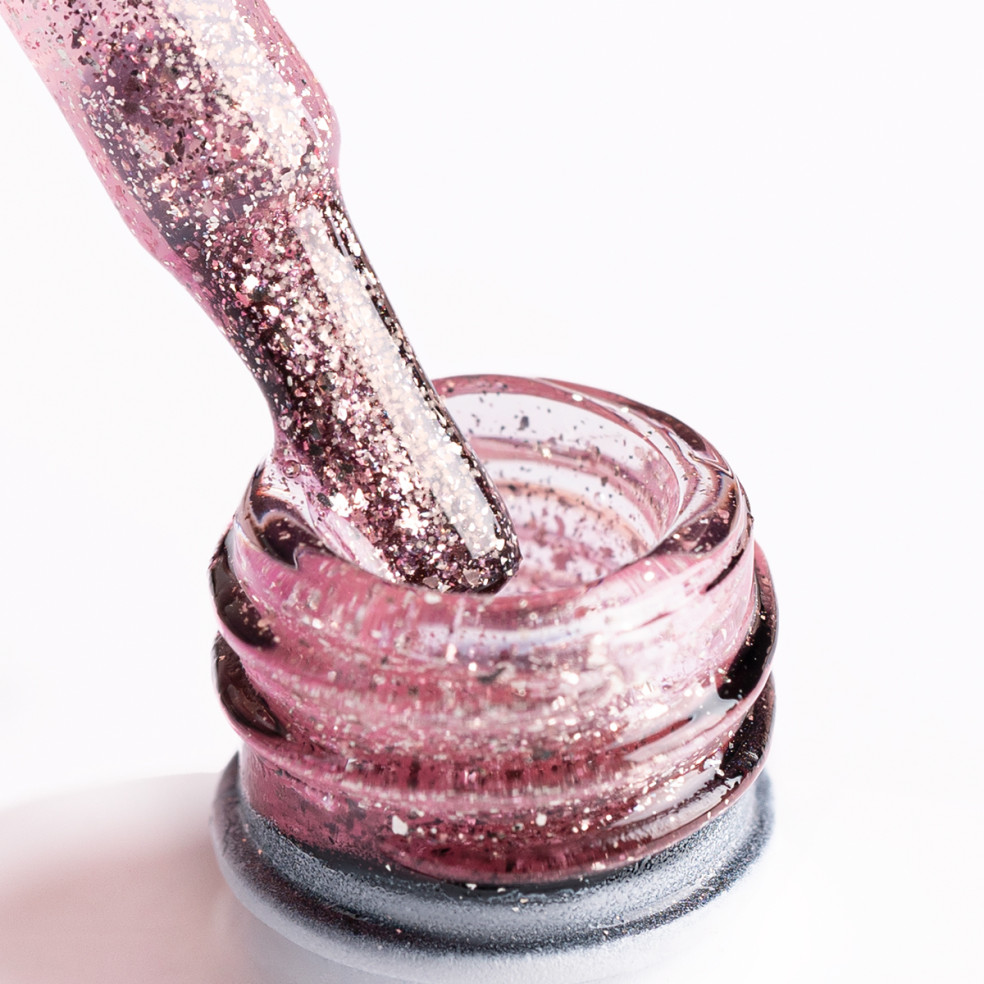 Pędzelek zanurzony w brokatowym lakierze hybrydowym w kolorze różowego złota Pędzelek zanurzony w brokatowym lakierze hybrydowym w kolorze różowego złota