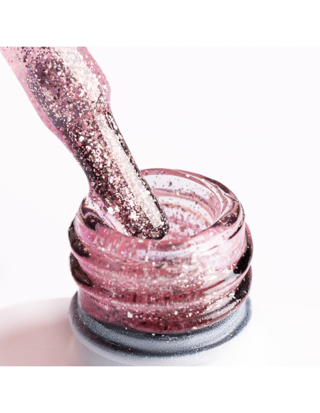 Pędzelek zanurzony w brokatowym lakierze hybrydowym w kolorze różowego złota Pędzelek zanurzony w brokatowym lakierze hybrydowym w kolorze różowego złota