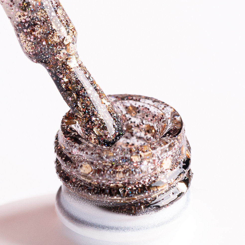 Pędzelek zanurzony w złotym brokatowym lakierze hybrydowym Pędzelek zanurzony w złotym brokatowym lakierze hybrydowym