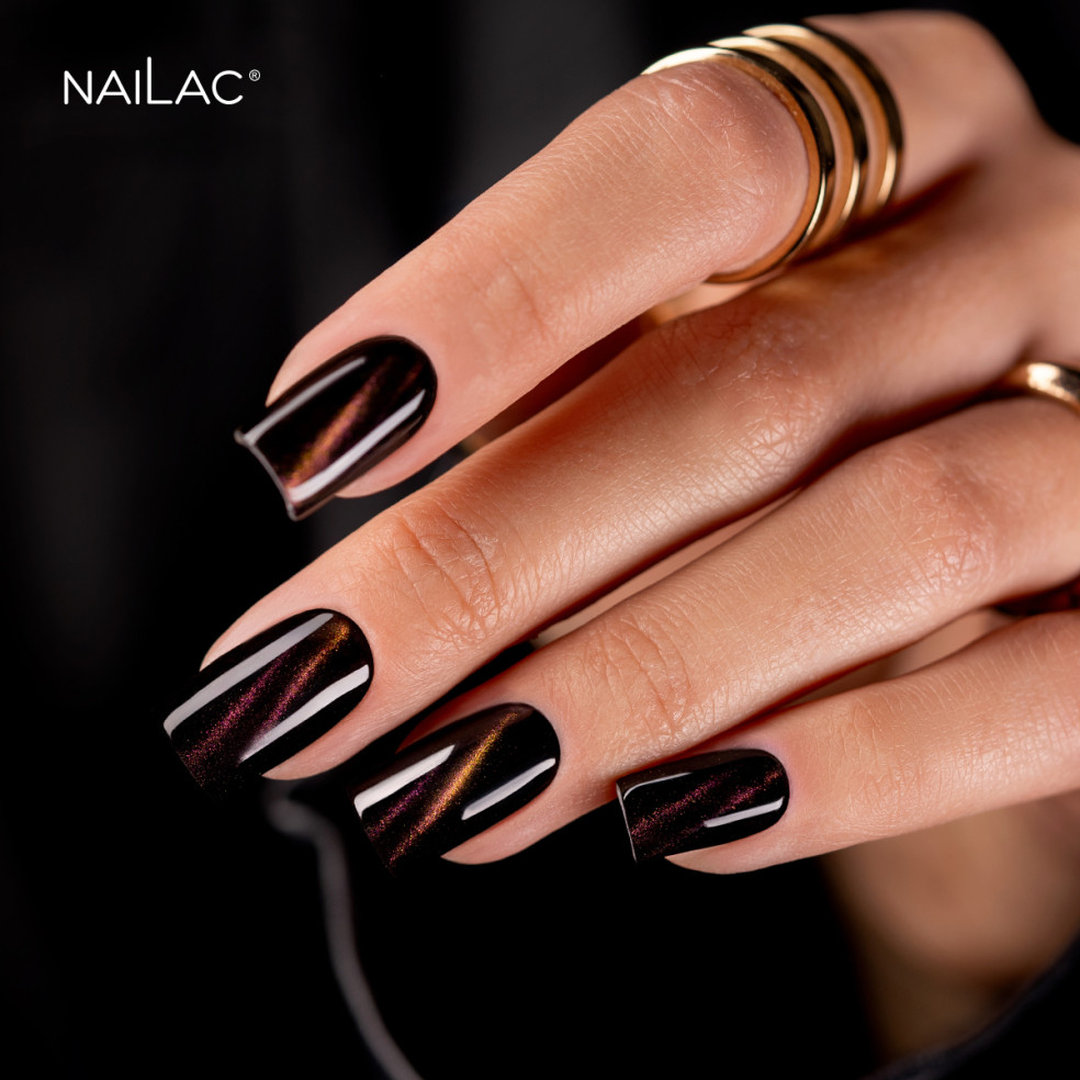 Paznokcie cat eye. Manicure wykonany za pomocą lakieru hybrydowego cat eye w odcieniach złoto-fioletowym Paznokcie cat eye. Manicure wykonany za pomocą lakieru hybrydowego cat eye w odcieniach złoto-fioletowym