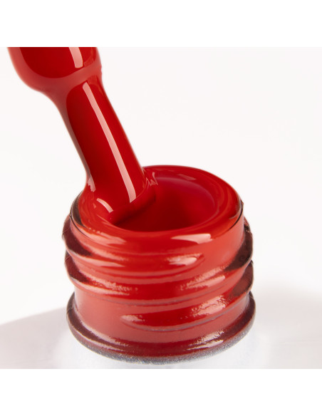 Szyjka butelki i pędzelek zanurzony w lakierze hybrydowym w odcieniu klasycznej czerwieni Szyjka butelki i pędzelek zanurzony w lakierze hybrydowym w odcieniu klasycznej czerwieni
