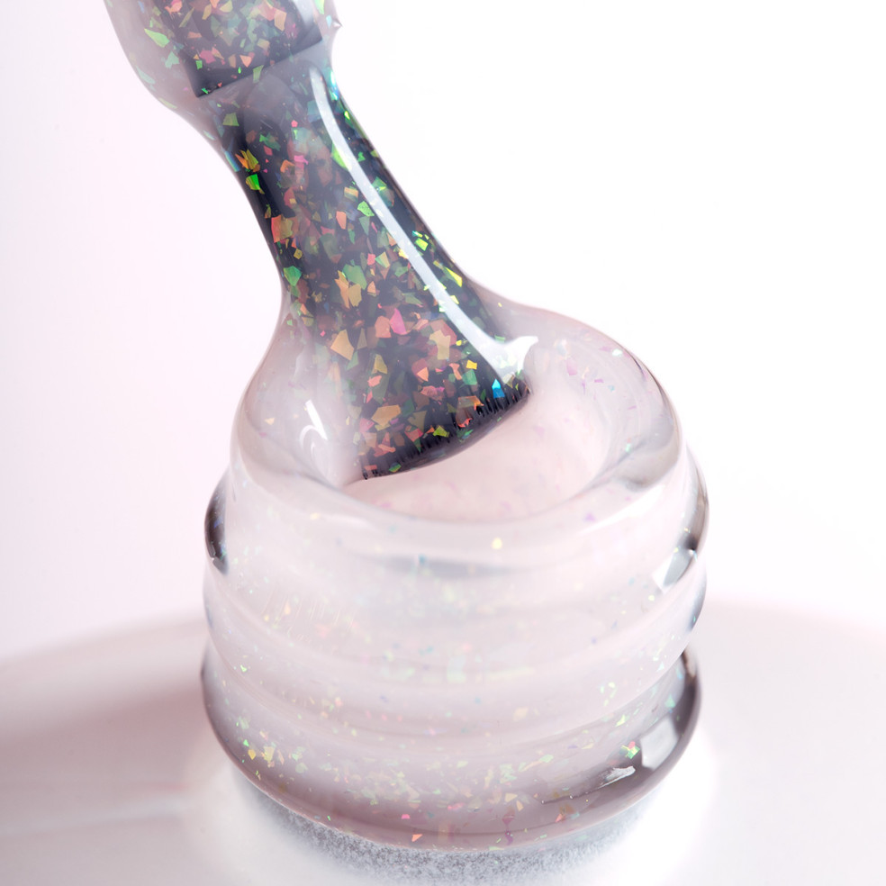Pędzelek zanurzony w mlecznym żelu do przedłużania z opalizującymi drobinkami