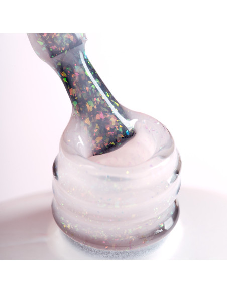 Pędzelek zanurzony w mlecznym żelu do przedłużania z opalizującymi drobinkami