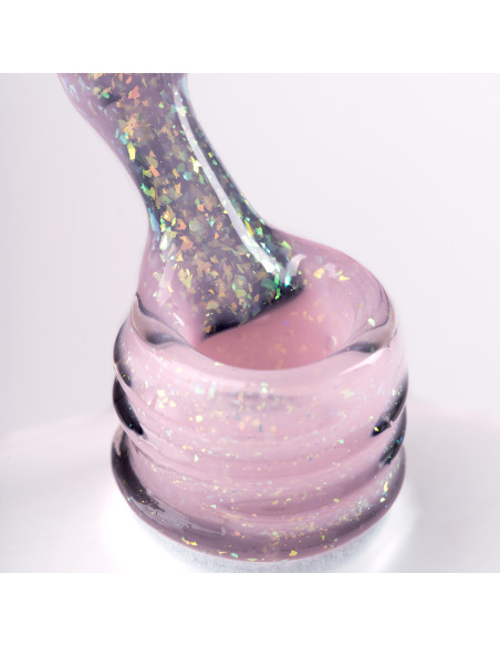 Pędzelek zanurzony w żelu do przedłużania w kolorze różowym z wielobarwnymi drobinkami