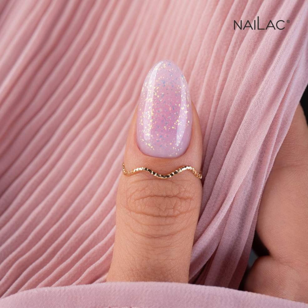 Kciuk pokryty różowym żelem do przedłużania paznokci z opalizującymi drobinkami