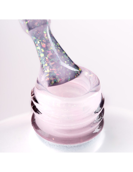 Pędzelek zanurzony w różowym żelu do przedłużania paznokci z wielobarwnymi drobinkami