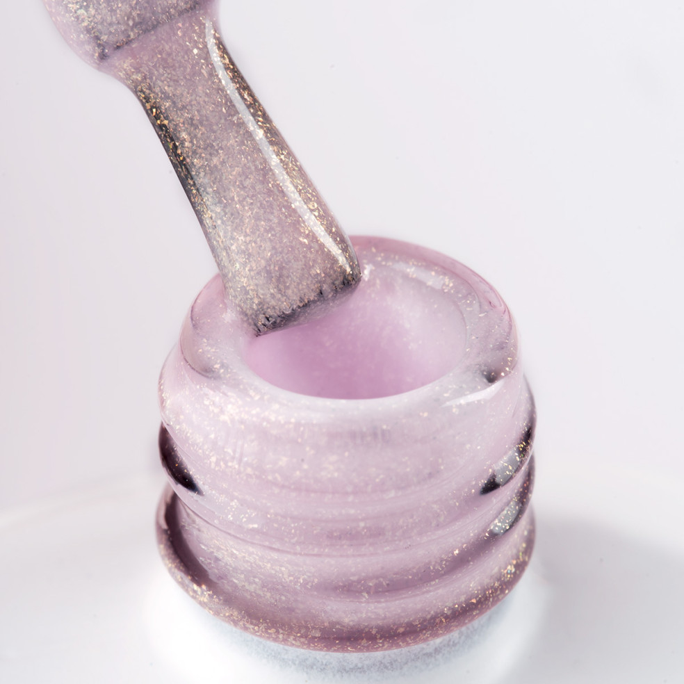 Pędzelek zanurzony w różowym żelu do przedłużania paznokci z brokatowymi drobinkami