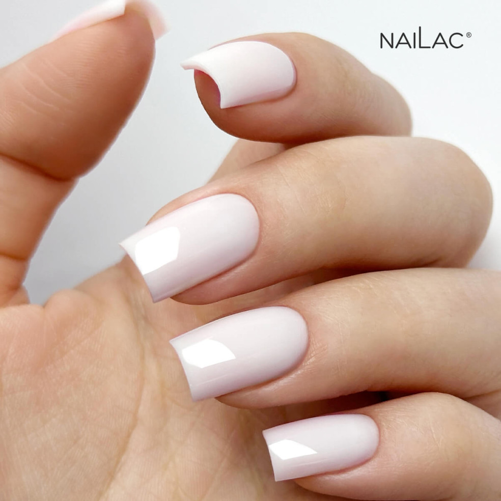 Manicure hybrydowy. Paznokcie pomalowane lakierem kauczukowym w kolorze półtransparentnym białym