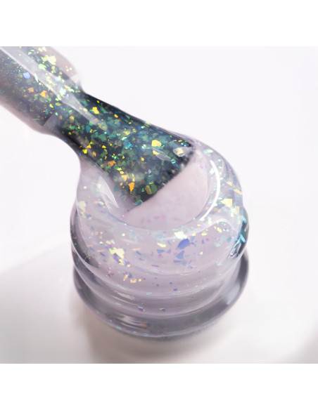 Pędzelek zanurzony w żelu do przedłużania paznokci w kolorze mlecznobialym z kawałkami ciętej folii