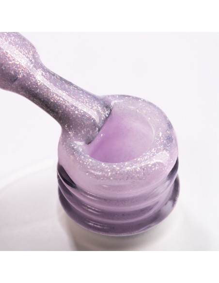 Pędzelek zanurzony w żelu do przedłużania paznokci w kolorze mlecznofioletowym z drobinkami brokatu