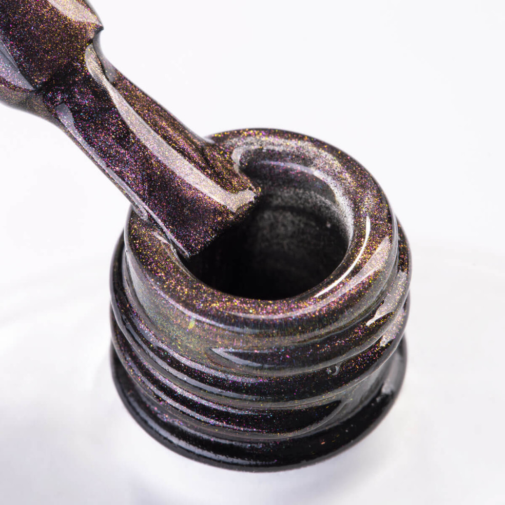 Pędzelek zanurzony w fioletowym lakierze hybrydowym cat eye