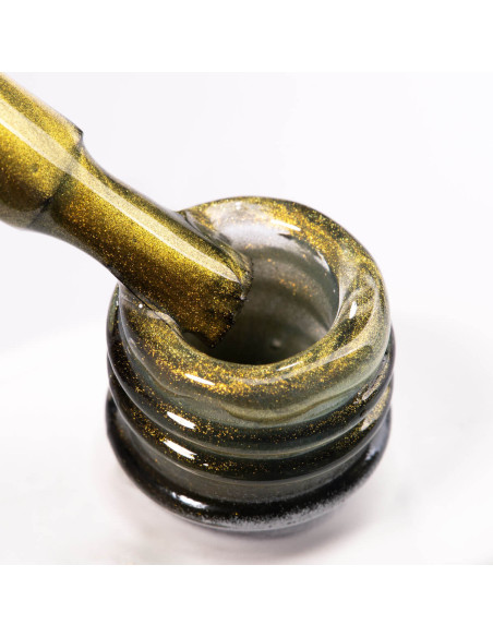 Pędzelek zanurzony w złotym lakierze z efektem cat eye