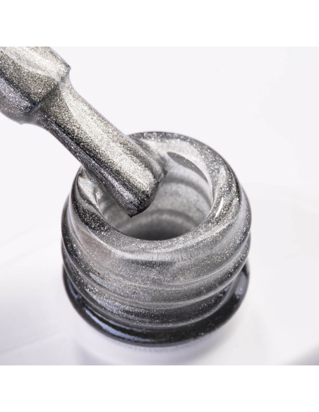 Pędzelek zanurzony w lakierze hybrydowym cat eye w kolorze srebrnym