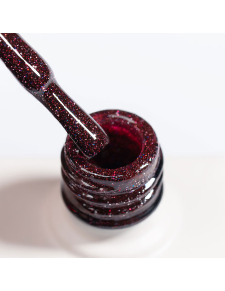 Pędzelek zanurzony w burgundowym lakierze hybrydowym z efektem flash - Sparkleholic