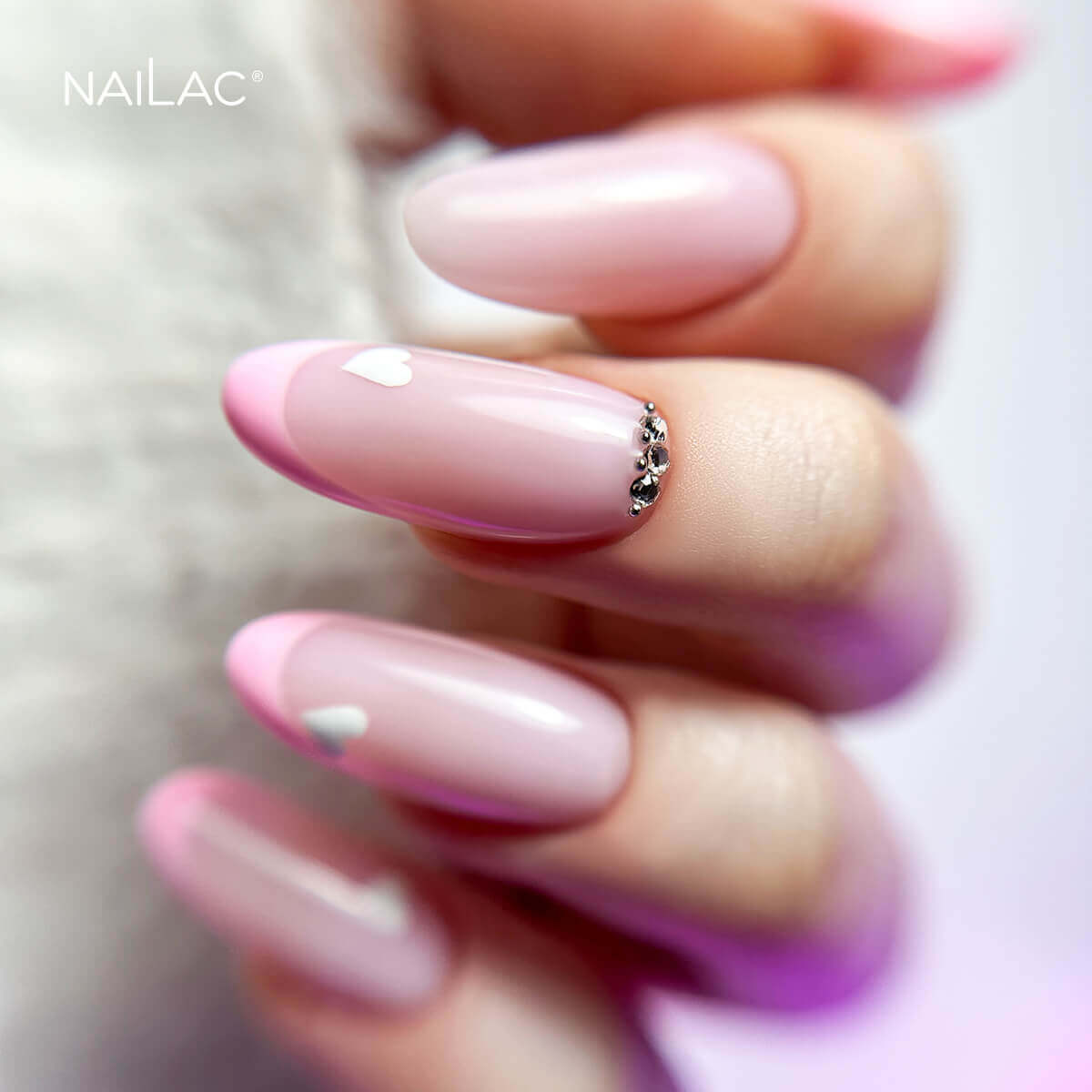 Manicure hybrydowy. Paznokcie w odcieniu nude ozdobione frenchem w kolorze jasnego różu